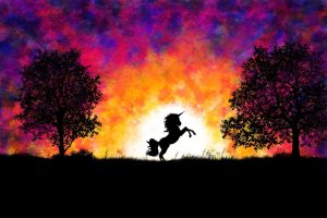 Einhorn im Sonnenuntergang zwischen zwei Bäumen